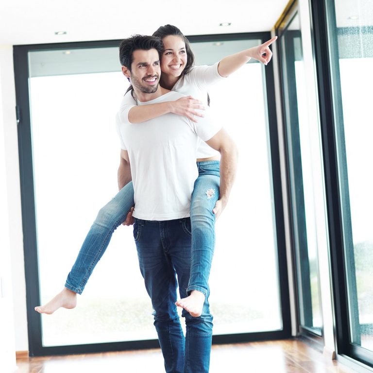 Bildrechte: Roma Ein Mann trägt eine lächelnde Frau auf dem Rücken, sie zeigen auf etwas außerhalb des Raumes.