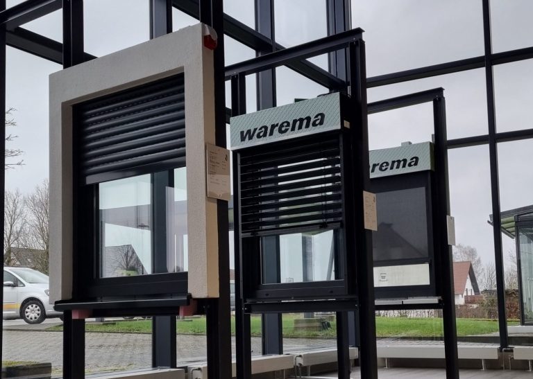 Bildrechte: Peters Fenster Fenster mit Rollläden in einem modernen Gebäude, Sicht auf den Außenbereich.