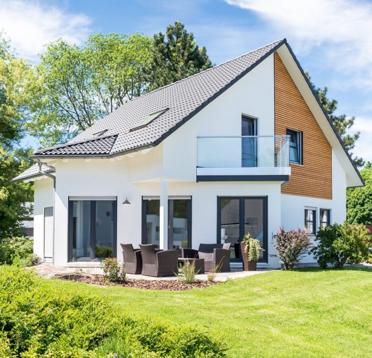 js-photo-stock.adobe.com modernes zweigeschossiges Wohnhaus mit Holzverkleidung und Gartenmöbeln im Freien
